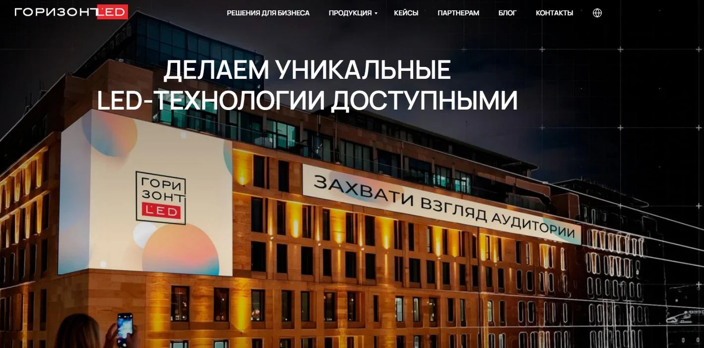 Horizon LED LED Screen Supplier - EagerLED | Leading LED Screen Supplier - EagerLED | Leading LED Screen Supplier Company storefront at night promoting affordable LED tech with large white banner on the building reading 'Захвати взгляд аудиторий' and 'ГОРИЗОНТ LED' logo nearby