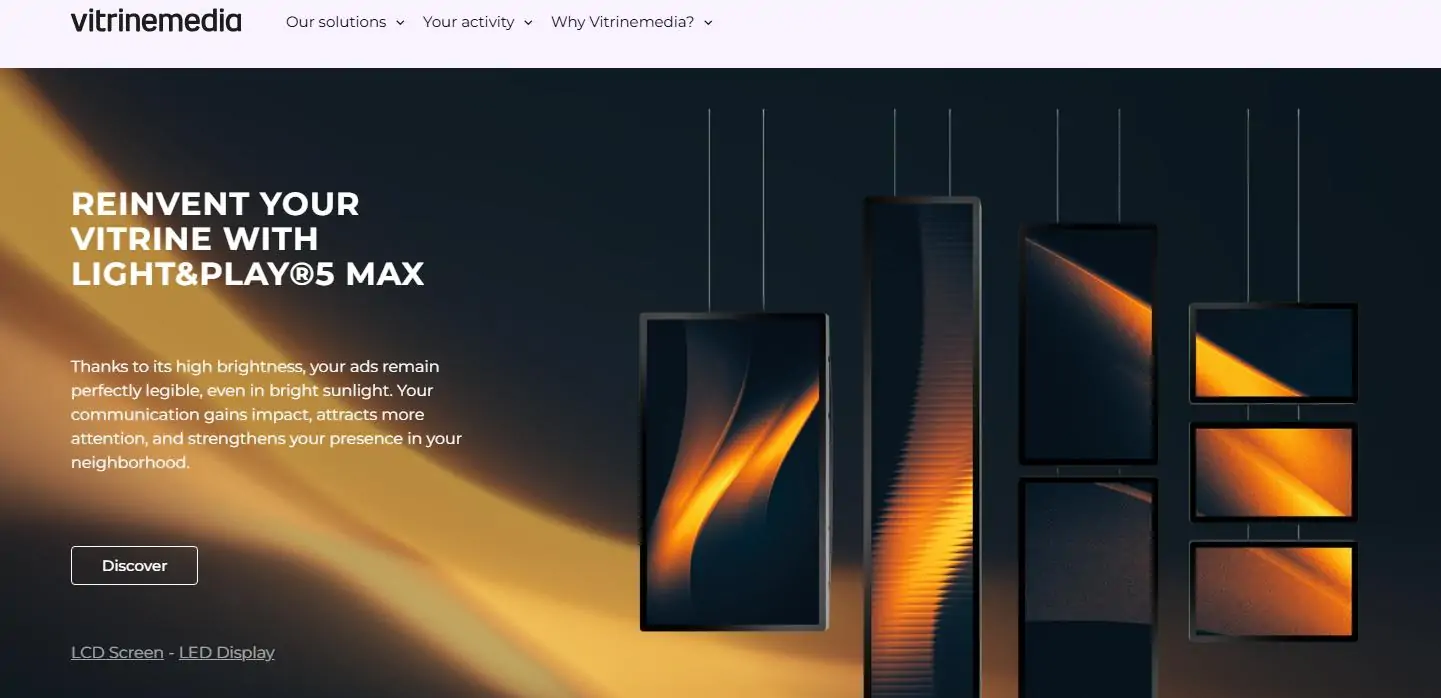 Promotional hero banner for VitrineMedia showing multiple hanging displays with orange glow on a dark background and the headline about Light&Play 5 Max.