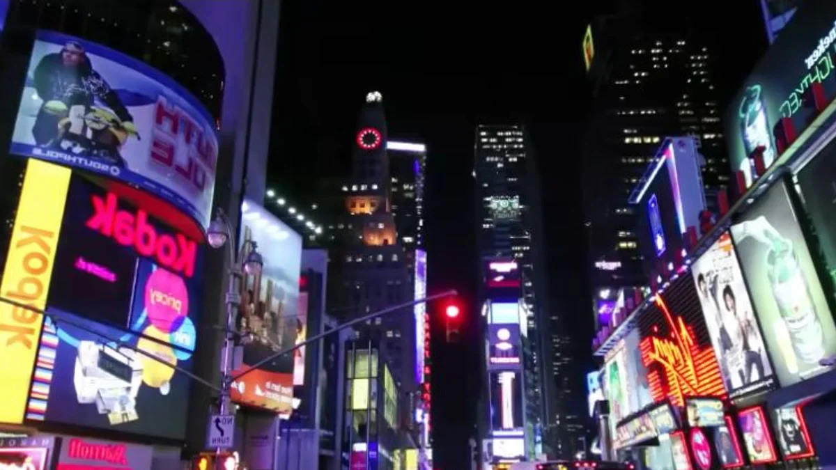 Large outdoor LED screens displaying colorful advertising in a city at night