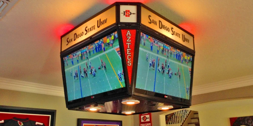 Four-screen mini jumbotron mounted in a home sports room
