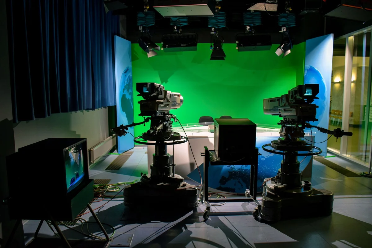 Professional cameras facing a green screen in a virtual production studio