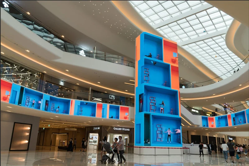 Indoor LED video wall installed in a shopping mall atrium and viewed by passing visitors
