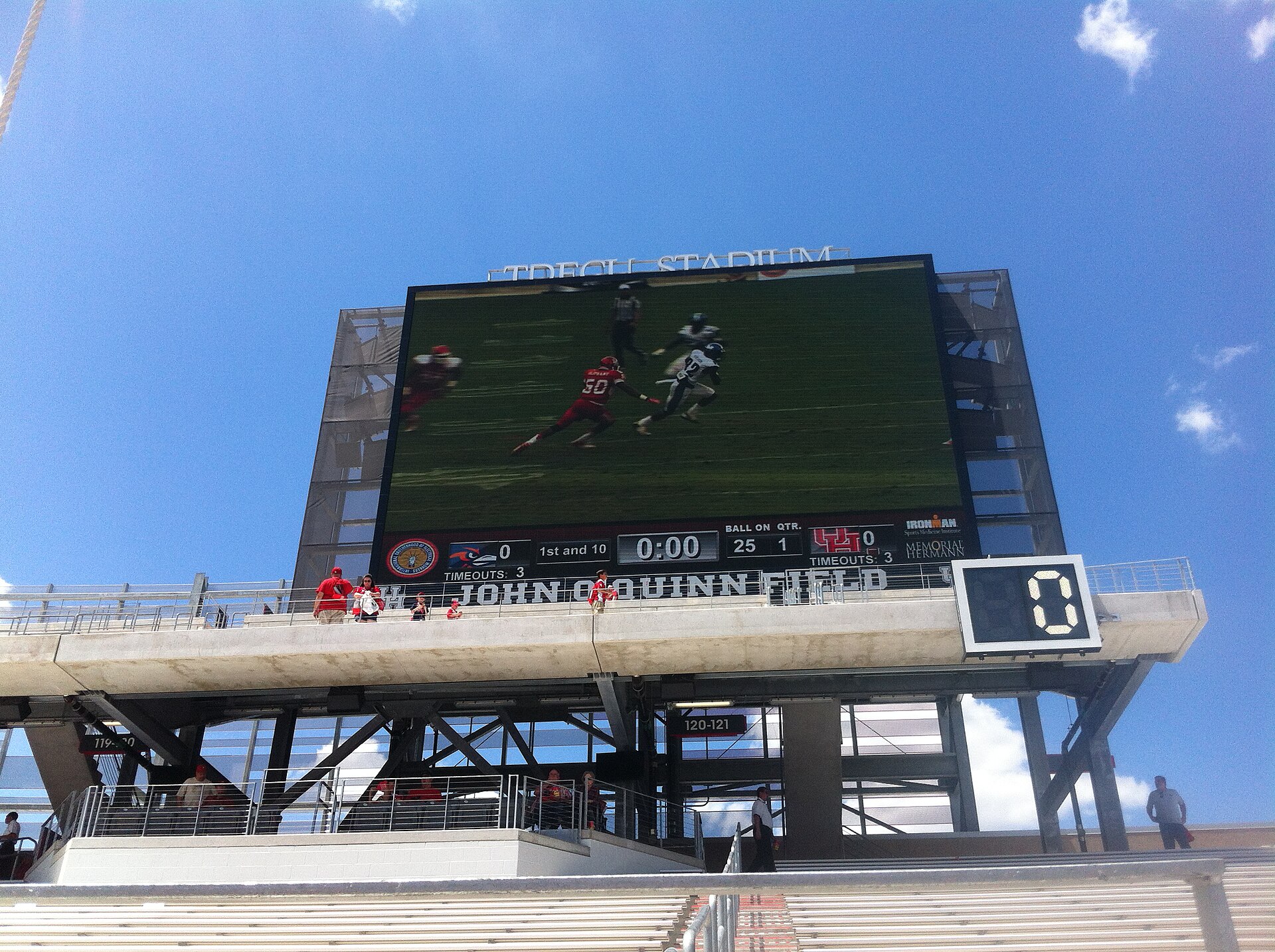 Outdoor stadium video board mounted on a steel support structure above the stand