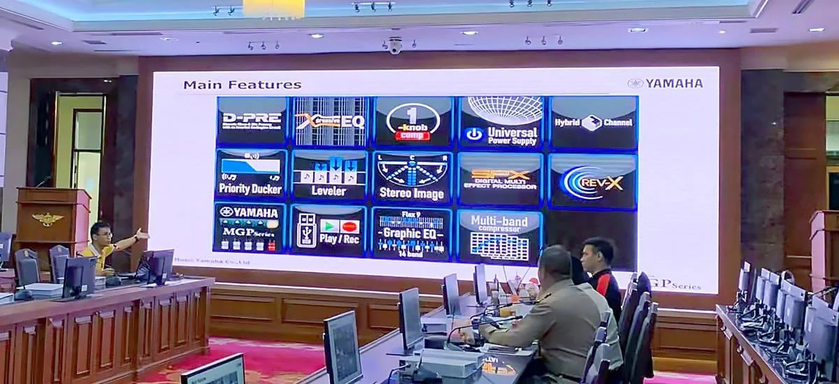 Meeting-room LED presentation wall showing detailed slides beside conference seating