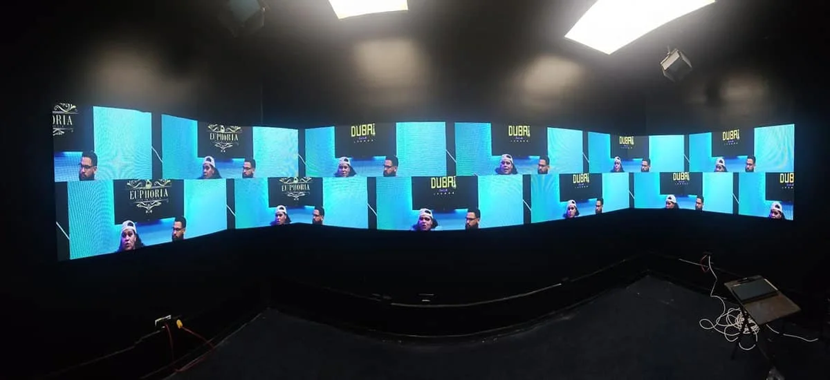 Indoor LED video wall displaying multiple video windows and bright graphics on dark backgrounds